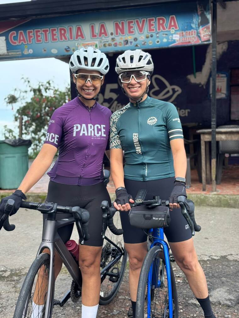 Dos parceras sonriendo con sus bicicletas